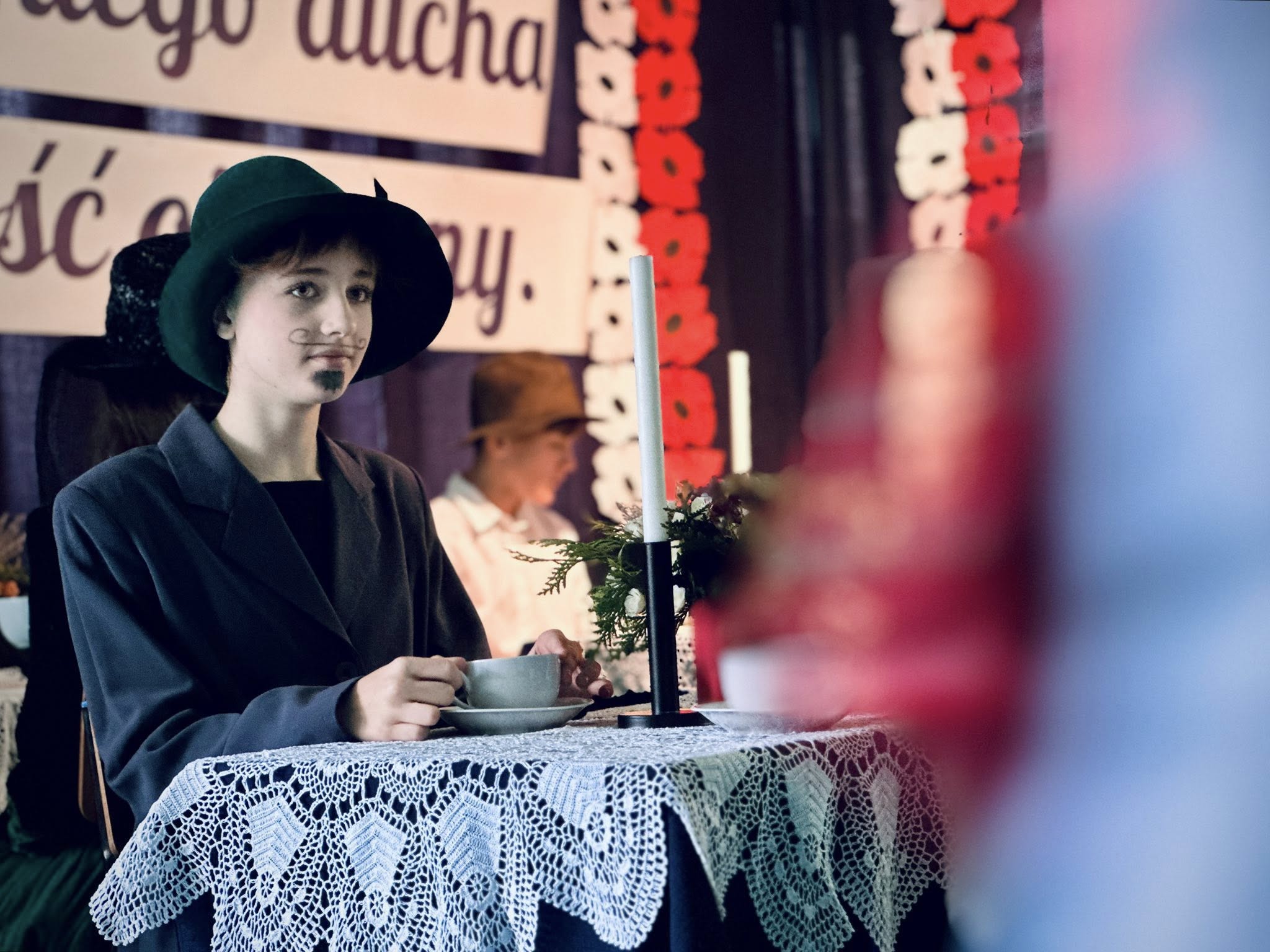 „Maria Skłodowska-Curie” czytająca gazetę w kawiarni – zbliżenie.
